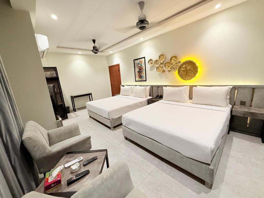 a hotel room with two beds and a couch at Legacy Dreams in Islamabad