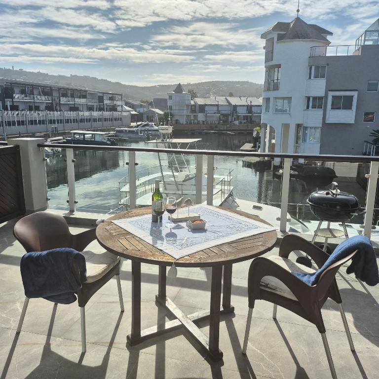 a table and chairs on a balcony with a view at South Quay no 6 in Knysna