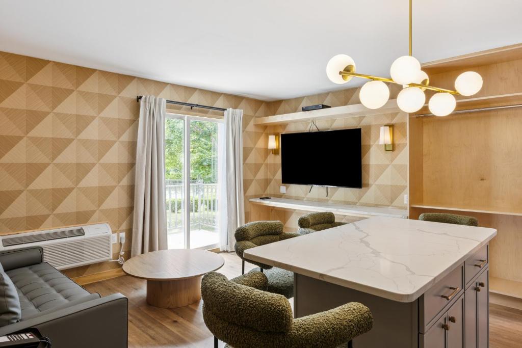 リバーヘッドにあるGreenview Inn Riverheadのテーブルと椅子のあるリビングルーム