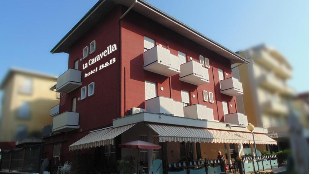 a tall red building with white boxes on it at Hotel La Caravella in Bellaria-Igea Marina