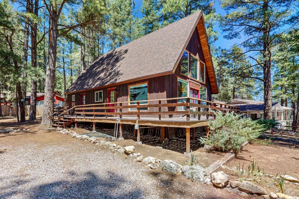 a cabin in the woods with a large porch at The Kachina Cabin in Mountainaire