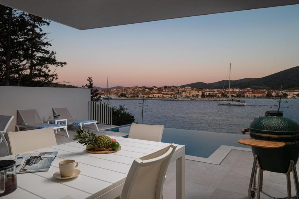 a table and chairs on a balcony with a view of the water at Villa Maslina in Vela Luka