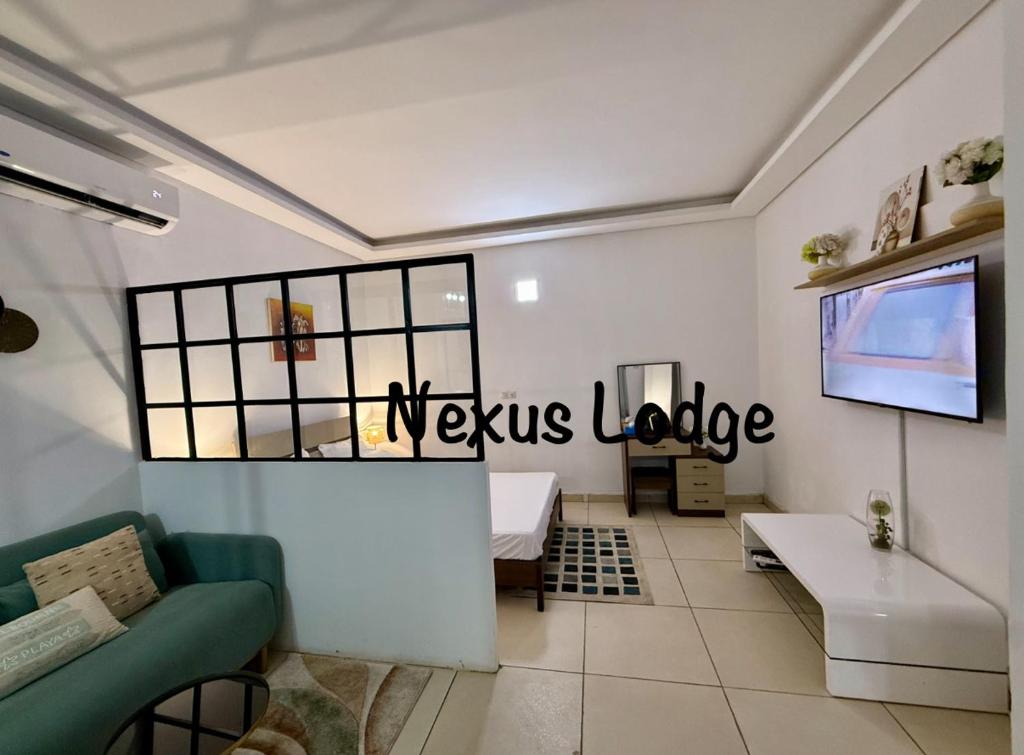un soggiorno con TV e divano di Nexus Lodge a Abidjan
