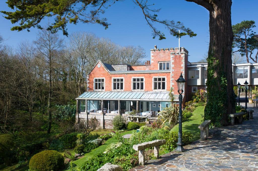 um grande edifício de tijolos vermelhos no meio de um parque em Hotel Meudon em Falmouth