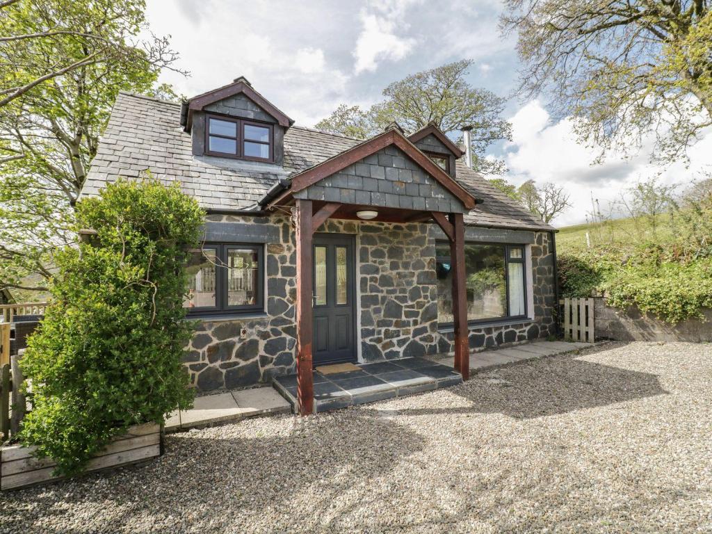 a small stone house with a wooden door at Cyffdy Cottage - Aran in Bala