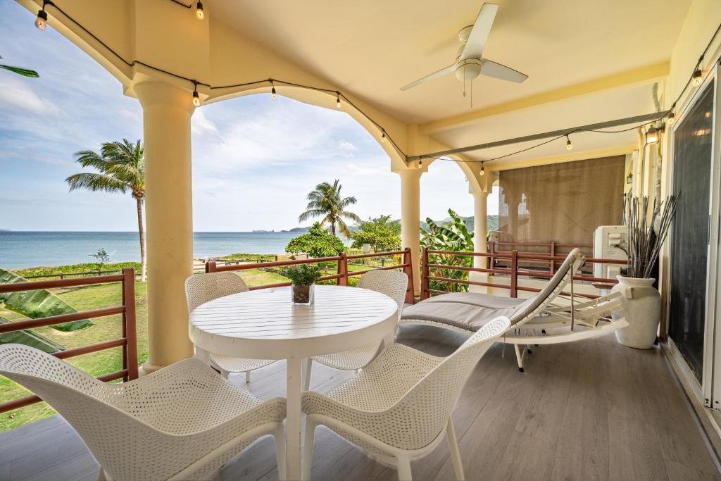 a balcony with a table and chairs and the ocean at Twin Dolphins 2A in Playa Flamingo