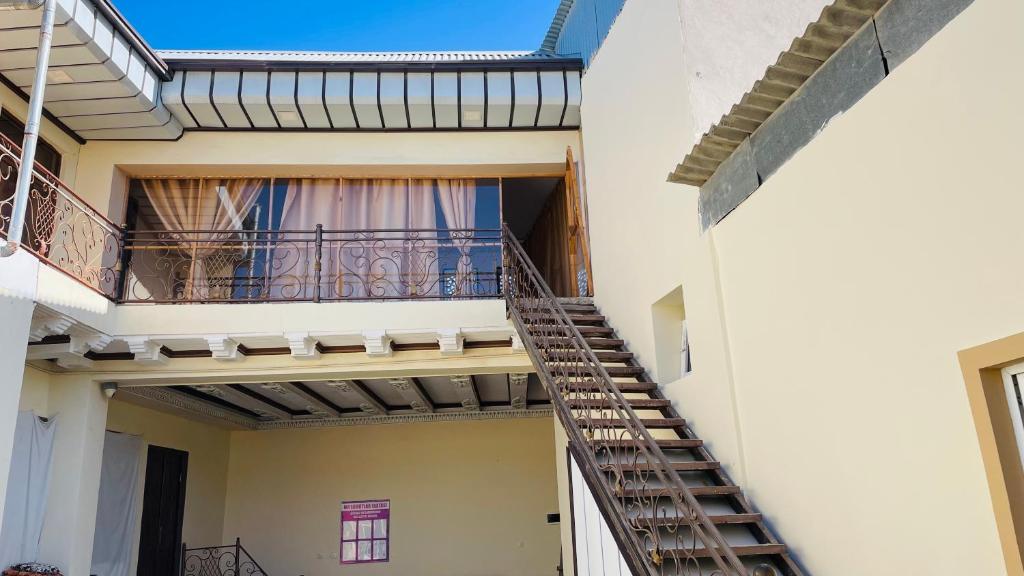 a staircase in a building with a balcony at Muhammadali hostel in Bukhara