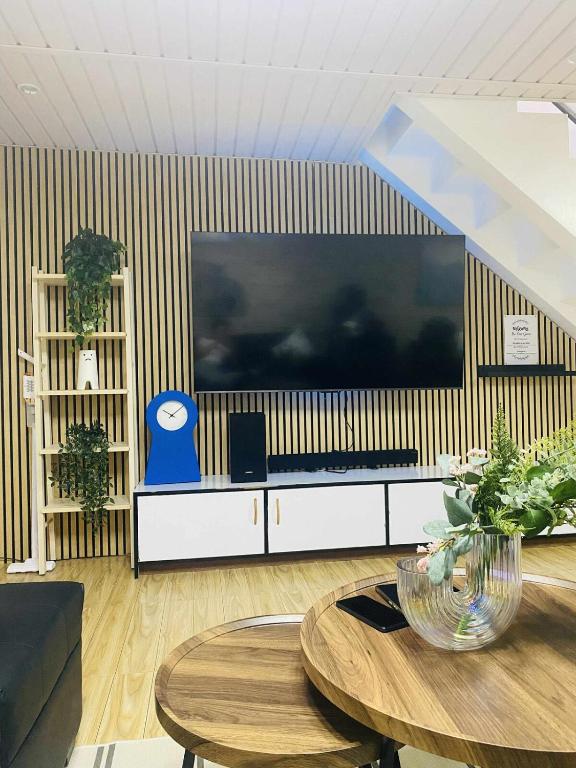 a living room with a large television on a wall at Bakers Home stay in Tacondo