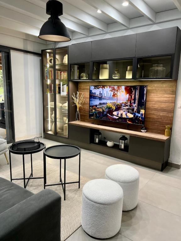 a living room with two tables and a tv at La Villa LIFE in La Plaine des Palmistes