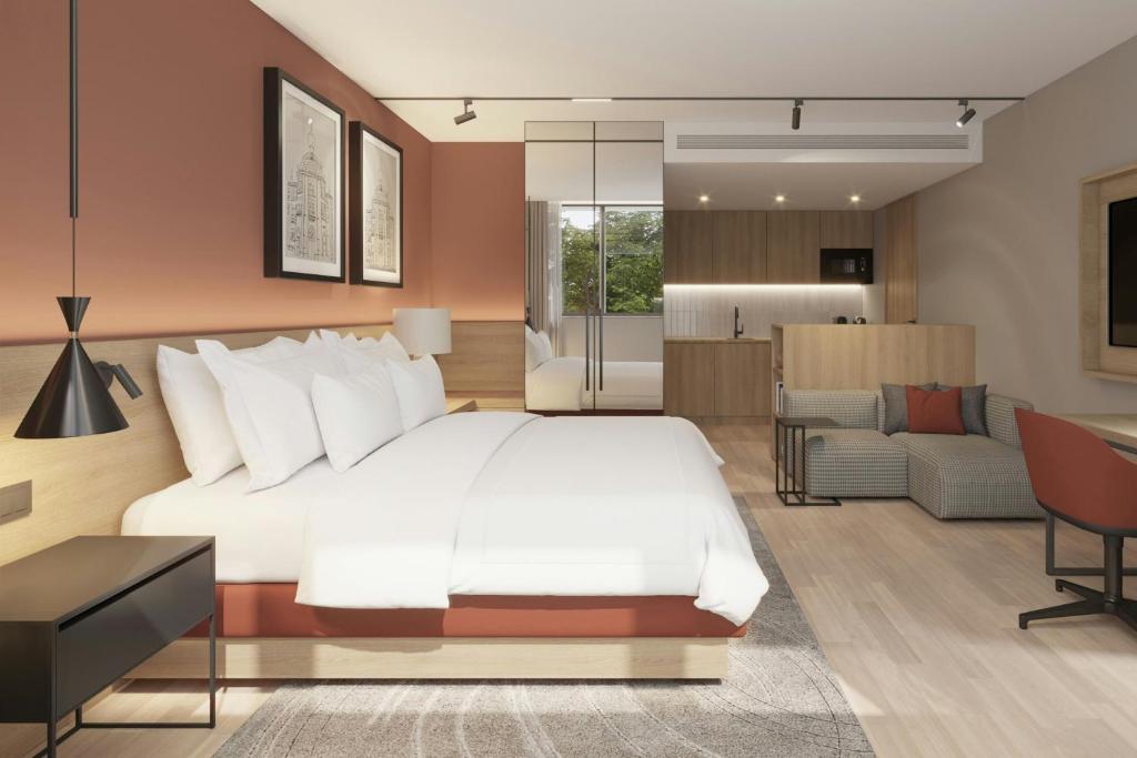 a bedroom with a white bed and a living room at Residence Inn by Marriott Lisbon in Lisbon