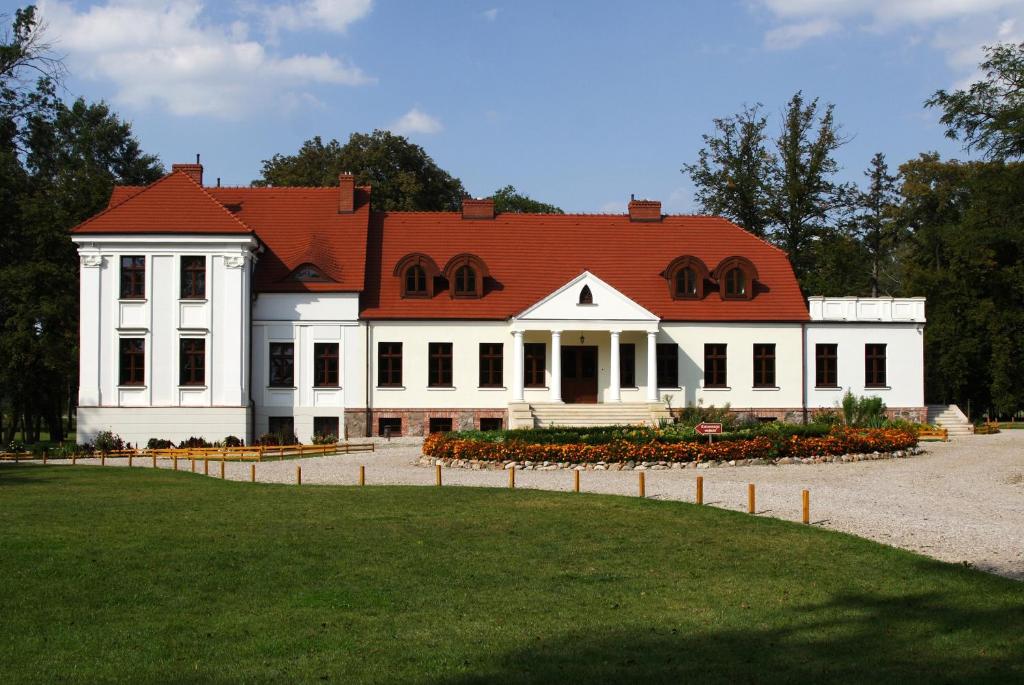 una gran casa blanca con techo rojo en Dwór Stary Chotów, en Kalisz