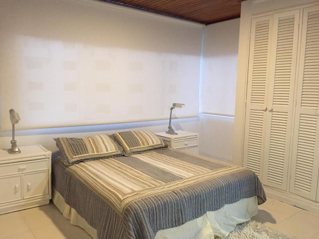 Un dormitorio con una cama con dos mesitas de noche y dos lámparas. en Ocean View San Andres Apartment, en San Andrés