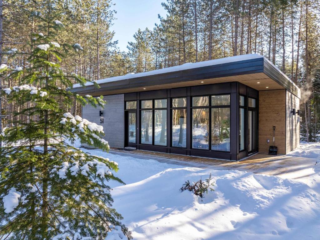 ein kleines Haus im Wald im Schnee in der Unterkunft Brand New with SPA - Le Repaire du Lievre Blanc in Saint-Alexis-des-Monts