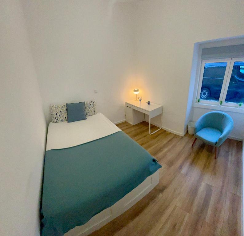 a small bedroom with a bed and a blue chair at Luxury and big house Sintra, free parking in Sintra