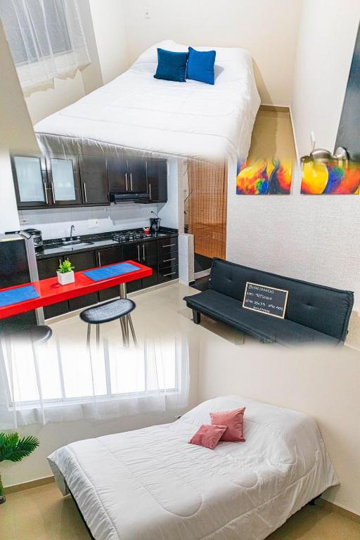 two beds in a room with a desk and a bed at Apartamentos Yuly Duque 302-401-404 in Bucaramanga