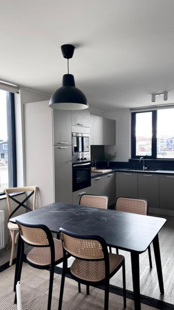 a kitchen with a table and chairs in a kitchen at Departamentos Natales in Puerto Natales
