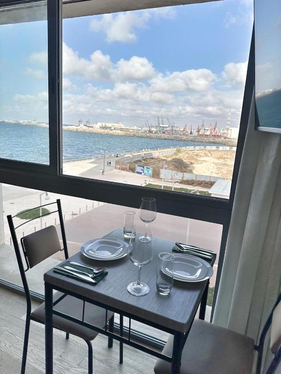 a table with wine glasses and a view of the beach at 3-marina Serena ocean-studio chic vue mer in Casablanca