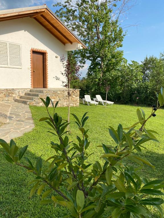 a house with two white chairs in a yard at Guest House Laci in Tirana