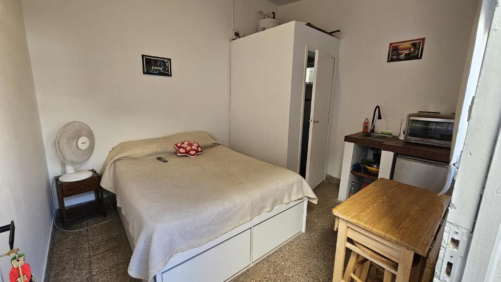 a small bedroom with a bed and a refrigerator at Sonido de mar in Santa Teresita