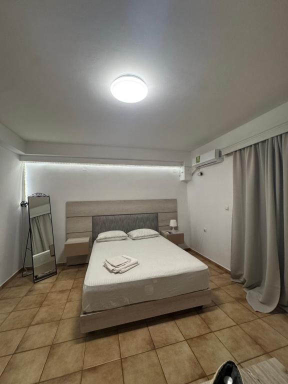 een slaapkamer met een bed en een licht aan het plafond bij Larisa City Ap 5 with parking in Larisa