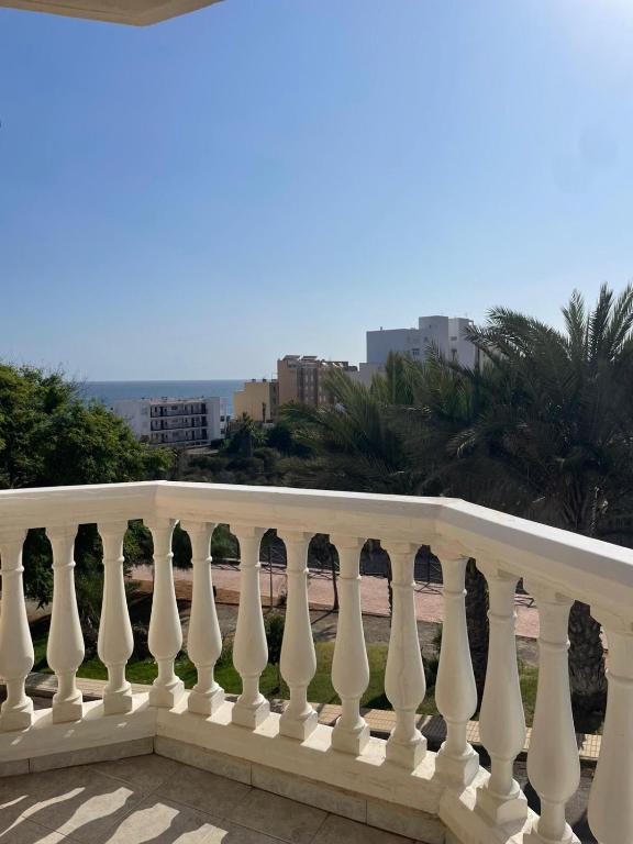 a white railing on a balcony with palm trees at Balcón al mar in Adra