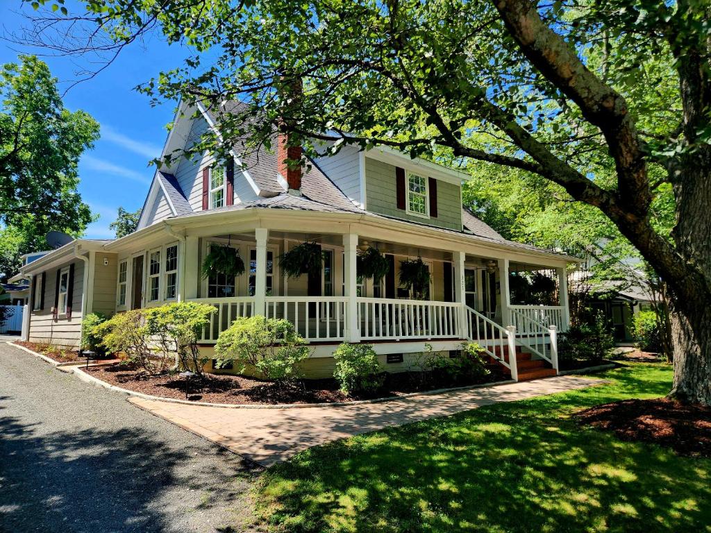 a green house with a white porch at Downtown Cary 1930s Bungalow - Great walkability in Cary