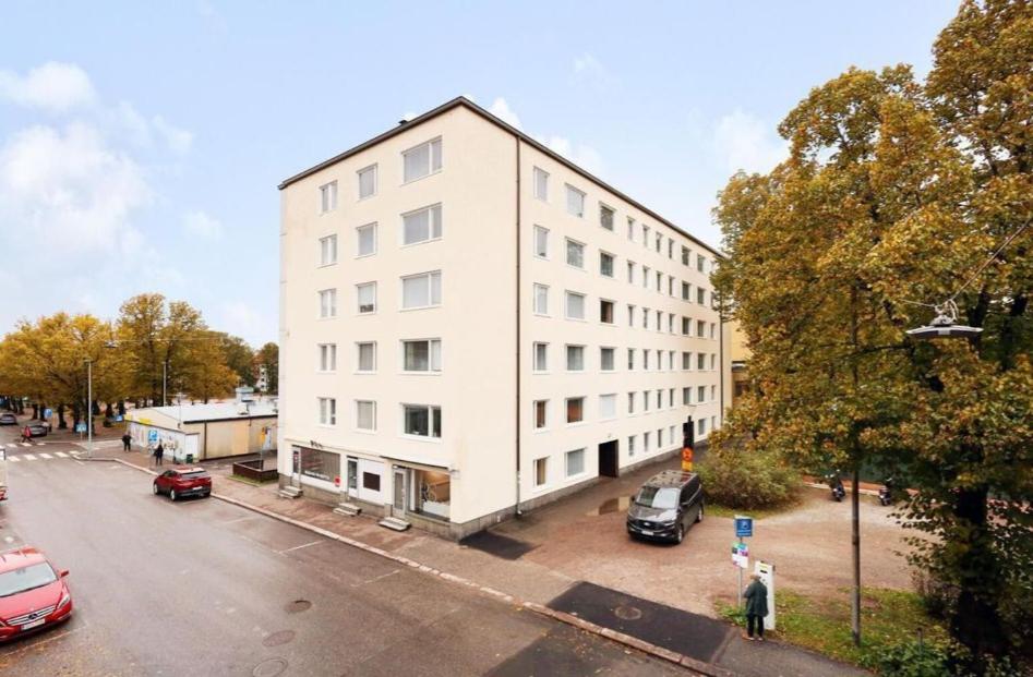 a white building with a parking lot next to a street at Porvoo Central Apartment in Porvoo