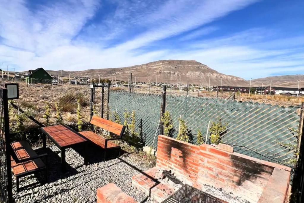 eine Bank und ein Tisch vor einem Gewässer in der Unterkunft LUXURY Casa cerca al centro en El Calafate Glacial, Argentina in El Calafate