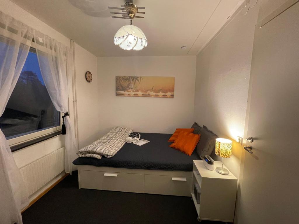 a small bedroom with a bed with a window at Independent Cozy apartment in husby in Stockholm