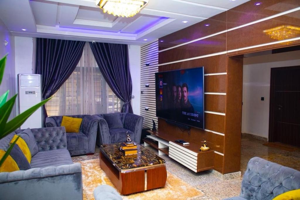 Una sala de estar con sofás y un televisor de pantalla plana. en 1 Bedroom Apartment in lifecamp, en Gwarinpa