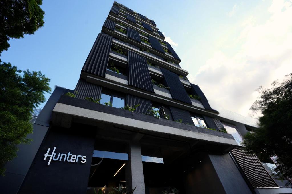 a tall black building with a sign on it at Hunters Hotel by Jalo in Medellín