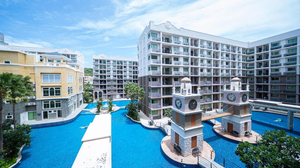 un complejo de apartamentos con piscina frente a dos edificios en Arcadia Beach 芭提雅市中心公寓, en Pattaya South
