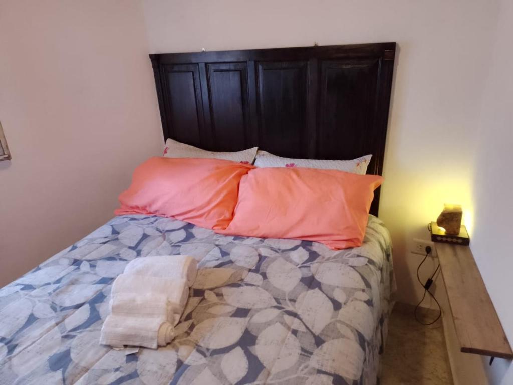 una camera da letto con un letto con cuscini arancioni di Entre Verdes alojamiento a Unquillo