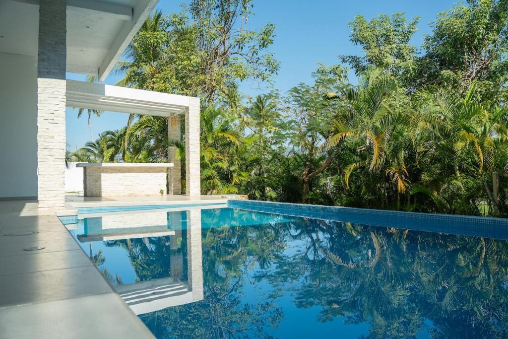 einen Pool in einem Haus mit Blick auf die Bäume in der Unterkunft NEW Bamboo Pacifica in Acapulco