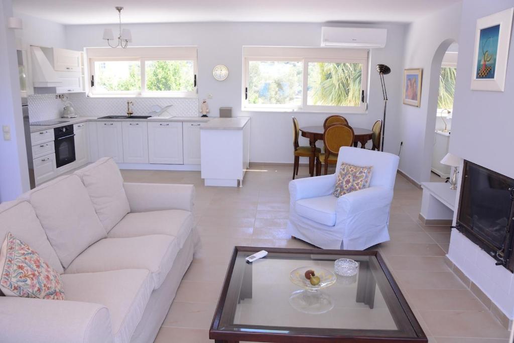 a living room with a white couch and a table at The Lakehouse in Vouliagmeni Lake