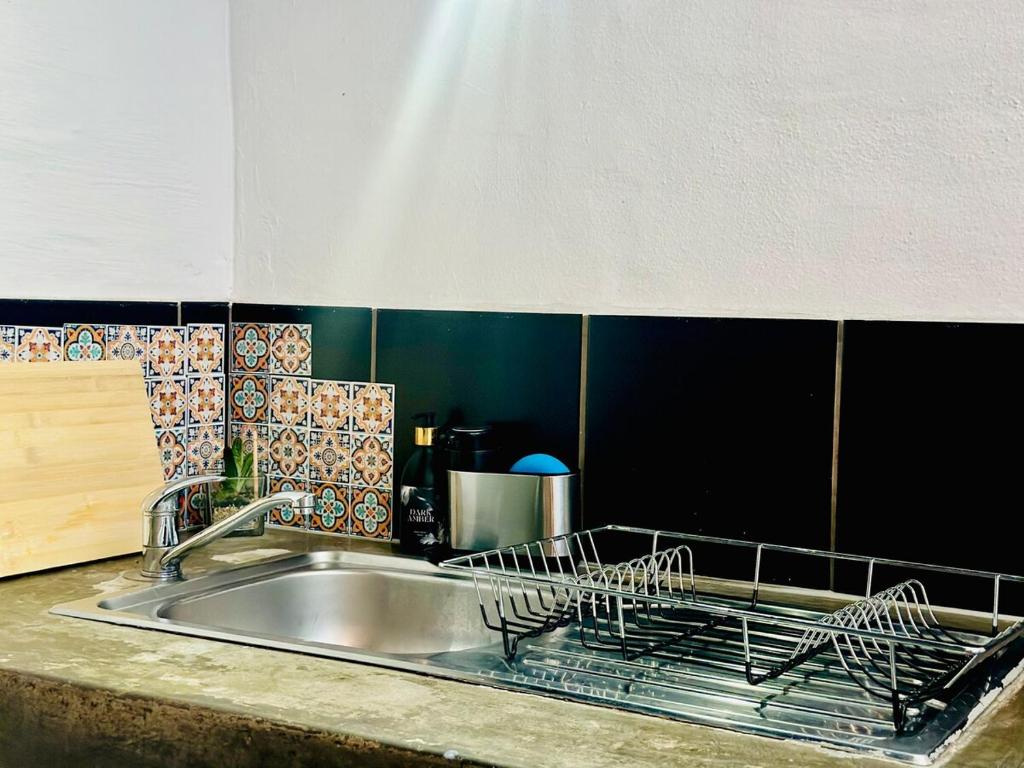 a kitchen sink with a dish drying rack on it at Cozy Luxury apt in Maboneng in Johannesburg
