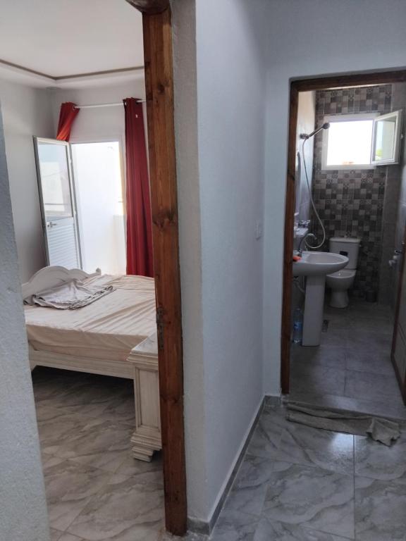 ザルジスにあるAppart 1 Zarzis centre villeのベッドと洗面台と鏡のある寝室