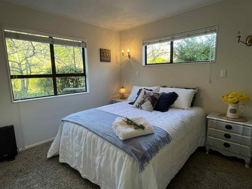 une chambre avec un grand lit avec deux fenêtres dans l'établissement Rose Cottage, à Clevedon
