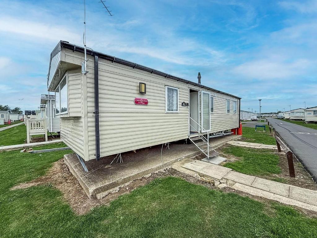 ein kleines weißes Haus am Straßenrand in der Unterkunft Lovely 6 Berth Caravan At St Osyth Beach Holiday Park In Essex Ref 28035Fi in Clacton-on-Sea