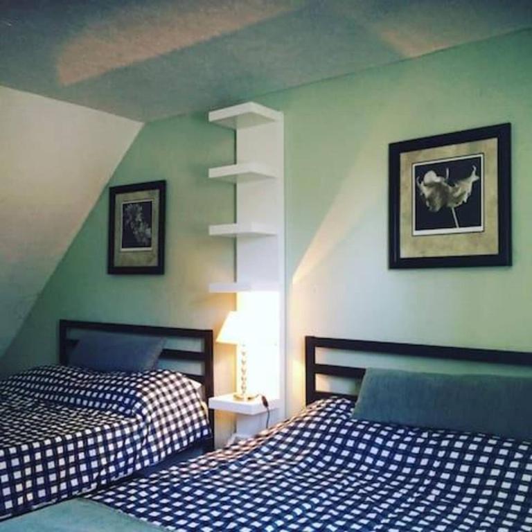 2 letti in una camera da letto con pareti verdi di Wasaga Beach Loft 4 a Wasaga Beach