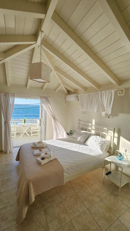 a bedroom with a bed with a view of the ocean at Ammos Boutique Rooms in Elafonisos