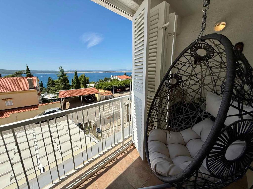 a swing on a balcony with a view of the ocean at Apartment in Dramalj 54763 in Dramalj