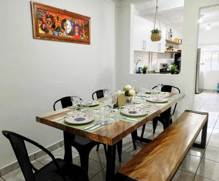 a dining room with a wooden table and chairs at CasaRomeroSV Casa completa 5 min de mall seguridad 3 cuart Lavad Sec aire ac 1pq in Mexicanos