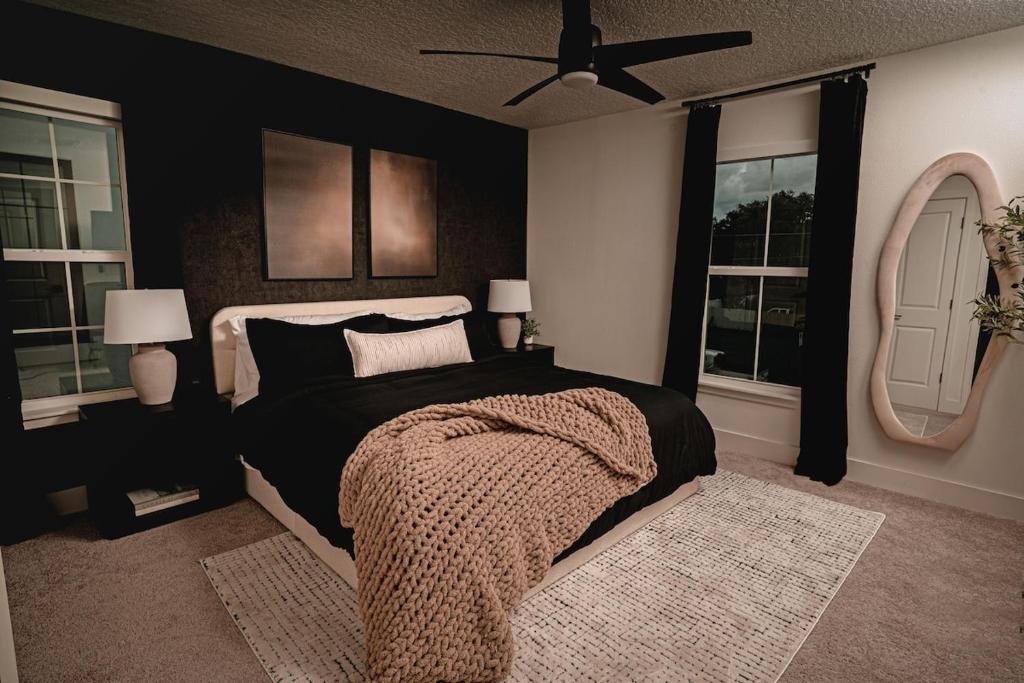 a bedroom with a bed with black walls and windows at 3BR-3BA Modern Ybor Central Tampa with Rooftop Firepit & 2 Bikes-Fully Equipped in Tampa