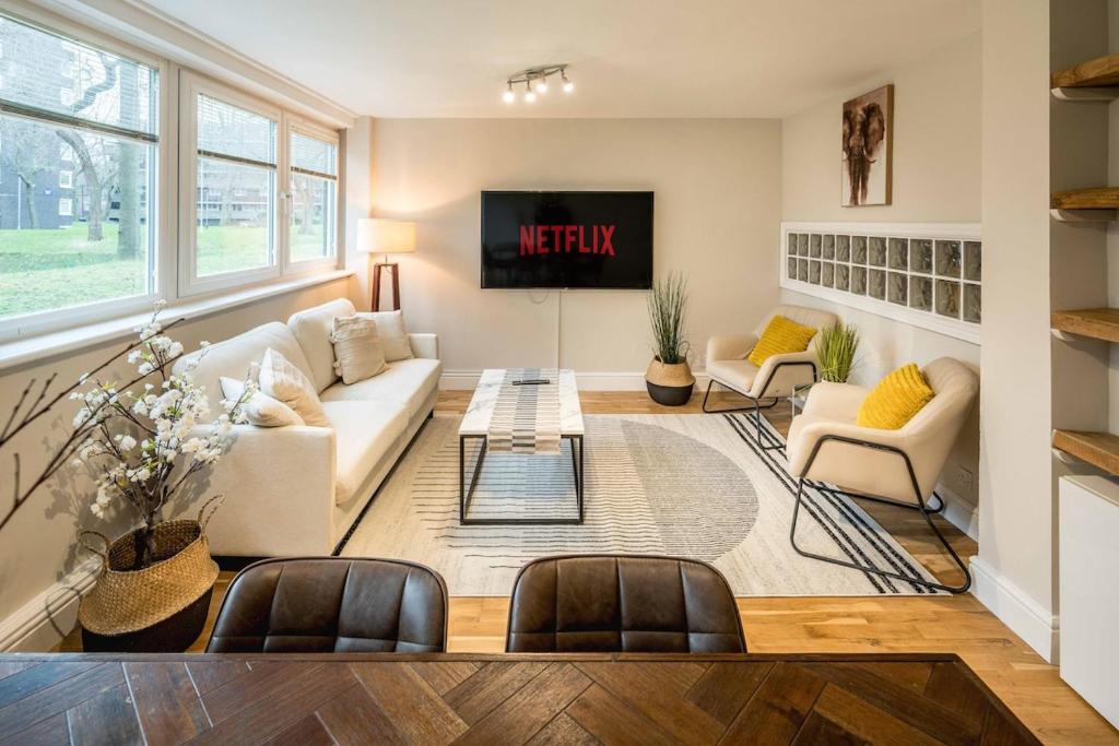 a living room with a white couch and chairs at 4BD Townhouse - Paddington! in London