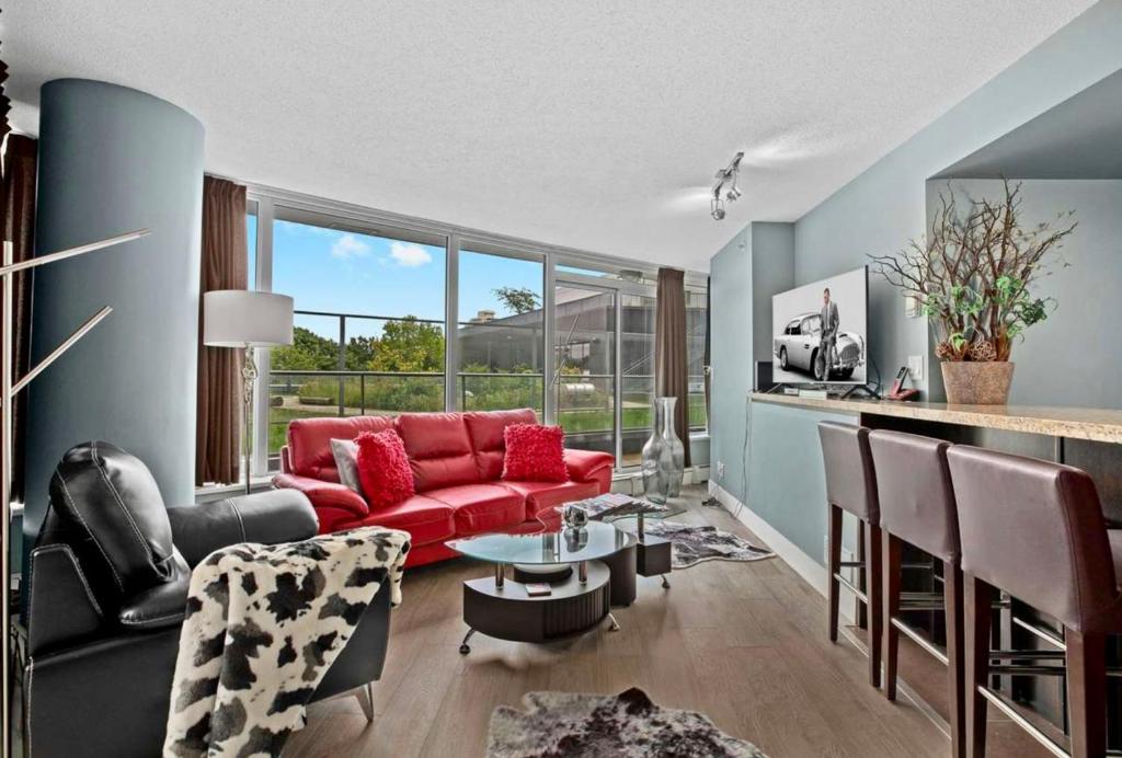 a living room with a red couch and a table at Luxury 2BR Designer Apartment - Prime Downtown Location! in Vancouver