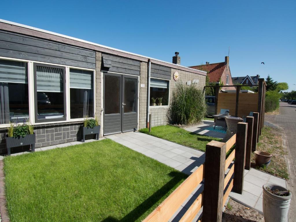 a house with a lawn in front of it at Modern 4-person bungalow near beach in Petten