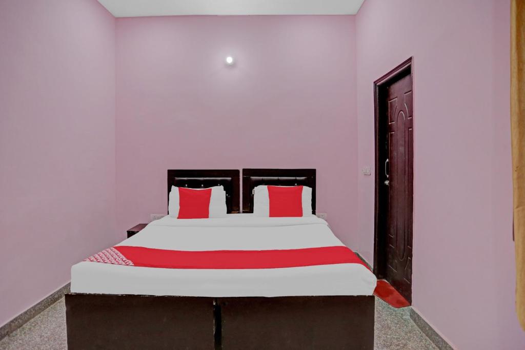 a bedroom with a large bed with red pillows at Hotel O AKKI RESIDENCY in Noida