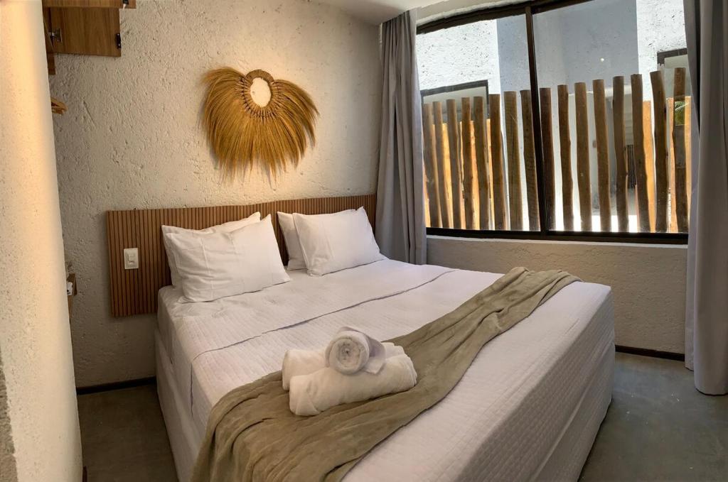 ein Hotelzimmer mit einem Bett mit einem Handtuch darauf in der Unterkunft Ap Piscina Privativa Próximo da capela dos Milagres in São Miguel dos Milagres