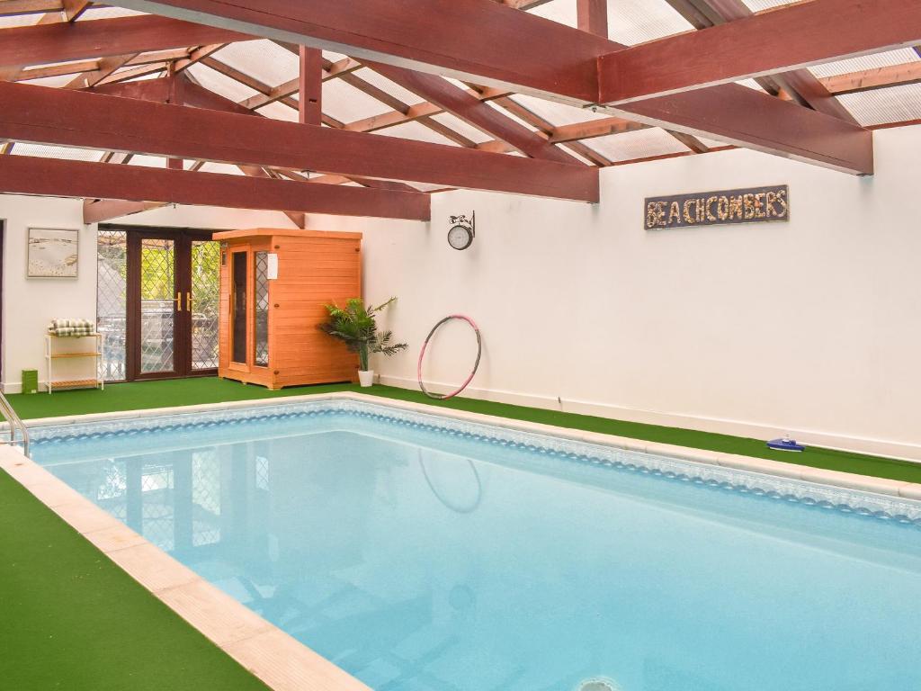 a large swimming pool in a building with a swimming pool at Puffin Cottage in Amble